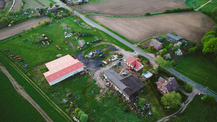 Aerial photo of a typical Polish hosing estate in the mountains towns, taken on a sunny part cloudy day using a drone, showing the housing estate and farmers fields.