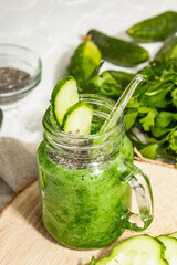 Green smoothie with cucumber in a glass jar. Fresh ripe vegetables, greens, and chia seeds