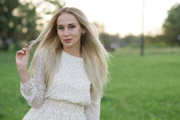 Naklejka premium Portrait of a stylish and attractive Caucasian blonde girl posing in the summer in the nature. Fashion concept.