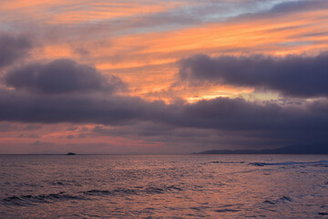 Seascape with purple clouds and orange sky - 458233034