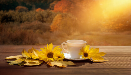 filiżanka kawy w jesienny poranek, kawa o poranku i żółte kwiaty słonecznika i jesienny widok na las - obrazy, fototapety, plakaty