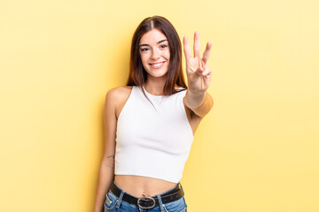 hispanic pretty woman smiling and looking friendly, showing number three or third with hand...