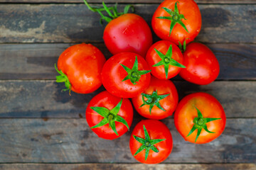 a lot of red tomatoes on a wooden background