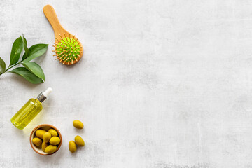 Olive oil for hair treatment with wooden hair brush