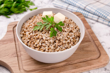 Freshly cooked buckwheat porridge in a plate on a gray background.