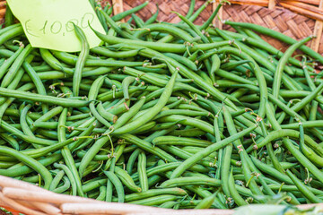 Green beans in a basket in a street food market with price, close up
