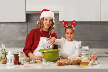 Mother and daughter making Christmas cookies in the kitchen 