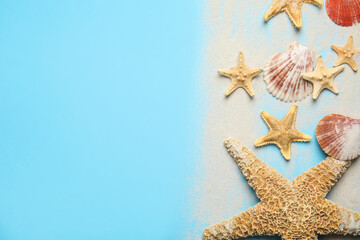 Fototapeta na wymiar Beautiful sea stars, shells and sand on light blue background, flat lay. Space for text