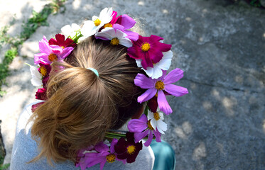 Naklejka premium a wreath of natural flowers on the girl's head, close-up