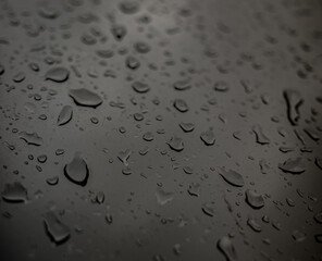 Drops of rain on a black dramatic window glass background. Autunm Rain, depression concept image.