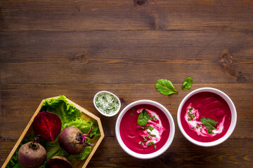 Beet soup with sour cream and fresh beet roots. Top view
