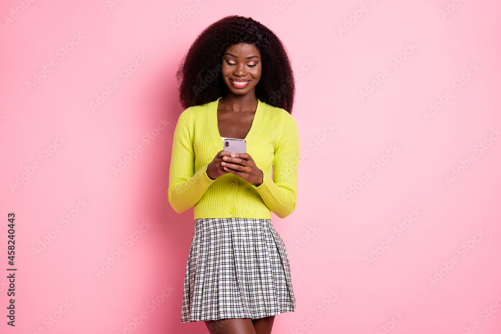 Sticker Photo of pretty cheerful dark skin lady typing blog post comment wear green isolated on pink color background