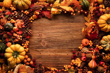 Naklejka na ściany i meble Autumn composition on a rustic wooden background. Decorative pumpkins, various leaves, pine cones, nuts. Orange, yellow, red and brown aesthetics. 