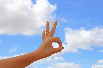 Hand with the ok sign with the blue sky in the background