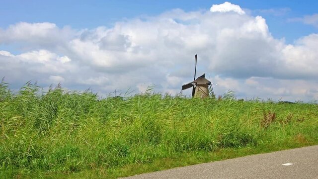 Traditional ancient windmills in the Dutch countryside. Outdoor tours and family bike tours in the Dutch countryside among the windmills. Netherlands typical landscape, tradional attraction park