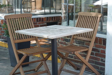 Fototapeta na wymiar Wooden chairs and marble table in outdoor restaurant