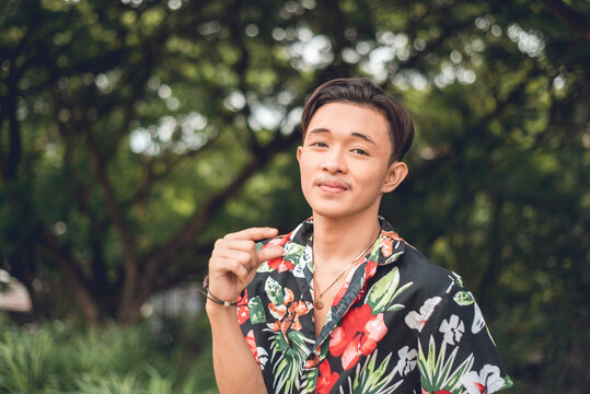 An asian man mocking someone gesturing a small manhood or package.