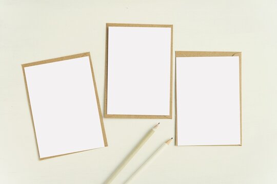 Set of 3 blank note cards and kraft paper envelopes for design presentation, A6 postcard, greeting card mockup, neutral colors, minimal style.