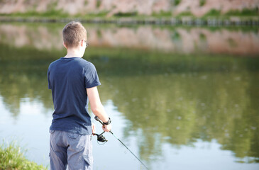 Young Man fishing on Lake with rod . Travel Lifestyle concept summer vacations.