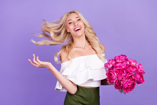 Photo of cheerful positive lady enjoy summer hold bunch peonies wear white blouse isolated purple color background