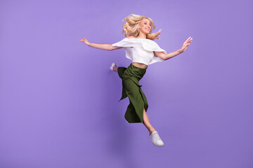 Full length body size photo blonde girl jumping up smiling doing stretching gracefully isolated...