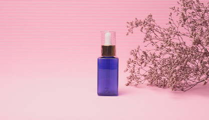 blue glass bottle with a dropper for cosmetics on a pink background. Packaging for gel, serum, advertising and promotion. Natural organic products