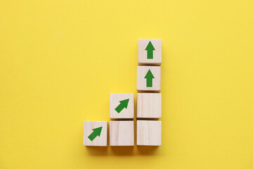 Wooden blocks lined up with up arrow icon The process of creating a successful business concept	