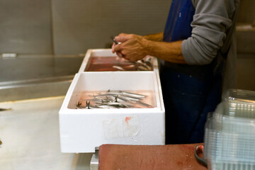 a seller who cuts and eviscerates fish