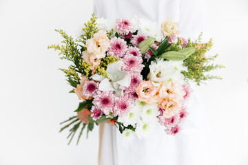 beautiful Caucasian I am a brunette girl in a white coat with a large bouquet of fresh flowers in her hands.