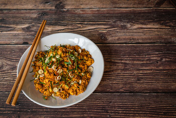Chinese stir fried tofu with spicy yellow curry, vegetarian food on wooden table