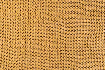 close-up of gold colored knitted fabric, textile background