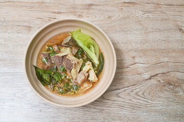 hot and spicy beef meat and organ with tamarind and Thai herbs soup on bowl