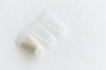disposable tubes for cream. Transparent plastic containers for cosmetics. White cream inside transparent containers. Home and professional skin care.