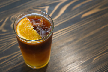 Glass of iced tea mixed tropical orange fruit refresh cocktail or mocktail drink favorite beverage.