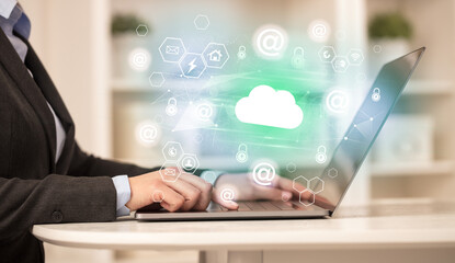 Hands working on laptop with digital icons