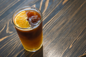 Glass of iced tea mixed tropical orange fruit refresh cocktail or mocktail drink favorite beverage.