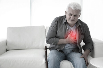 Senior man having heart attack on sofa