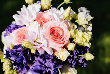 Wedding bouquet of flowers and gold wedding rings top view. Jewelry rings lie inside a rose outdoors.