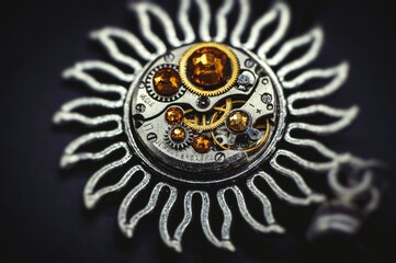 Nice handmade decoration pendant made of metal and watch parts with precious stones of different colors