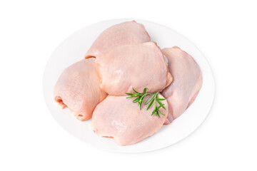 Pieces of raw chicken thigh on a white plate on a white isolated background. Fresh chicken thigh.