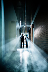 Security guards with flashlights in empty corridor