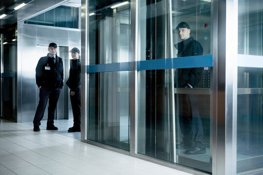 Portrait of security guards standing in corridor near elevator