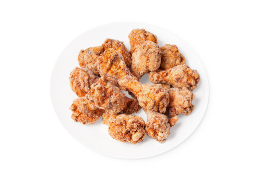 Frozen semi-cooked chicken wings on a white plate on a white background.Fast food, convenience food.