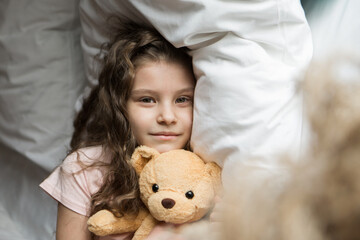 A beautiful girl with Teddy bear, a child with toy. The concept of childhood, morning pastime