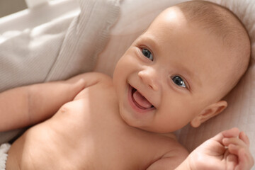 Cute little baby lying in soft crib