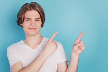 Happy guy isolated showing pointing promotion with index finger blue empty space background