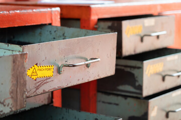 Metal drawer shelf box for keep the hand tool equipment in factory storage inventory room. Industrial object photo. Close-up and selective focus at the handle part.