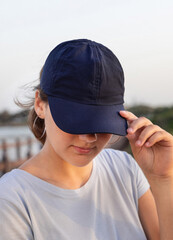 Teen girl in dark blue baseball cap and t-shirt
