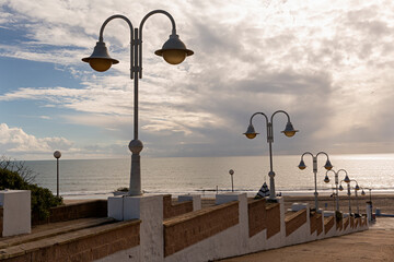 Paisaje de la playa y calle con farolas.