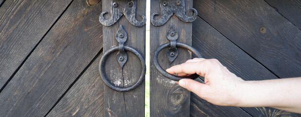 Woman's hand opens the ancient gate